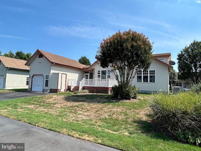 view of front of house featuring a porch, a garage, and a front lawn