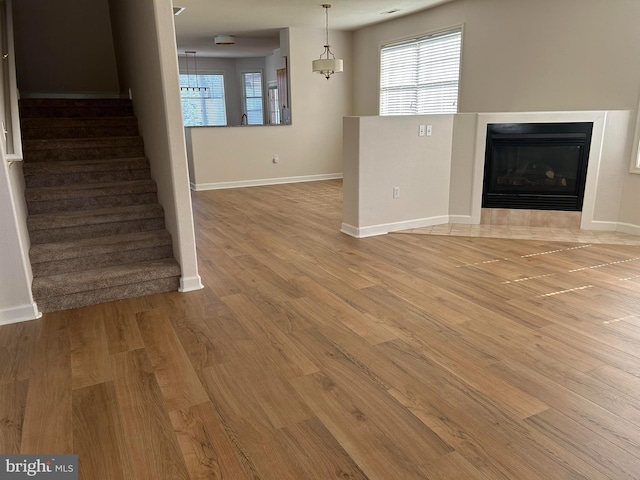 unfurnished living room with light wood-type flooring and a fireplace