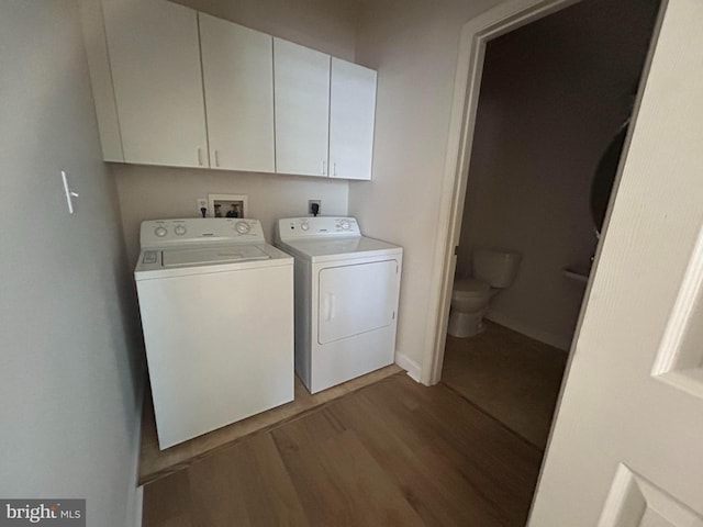 laundry room with washing machine and clothes dryer and hardwood / wood-style flooring