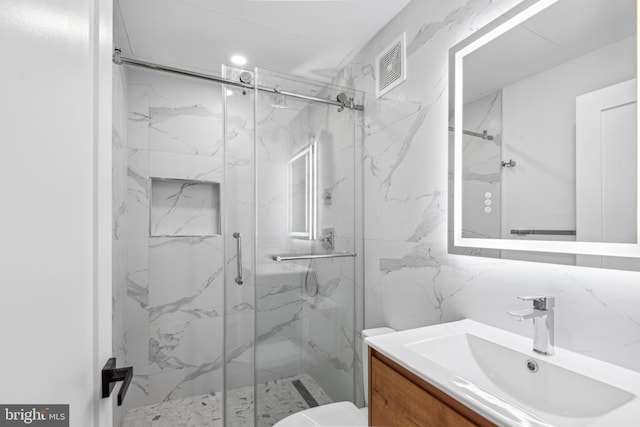 bathroom featuring vanity, toilet, and an enclosed shower