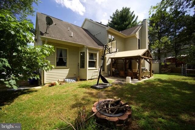 rear view of house with a gazebo, a yard, and an outdoor fire pit