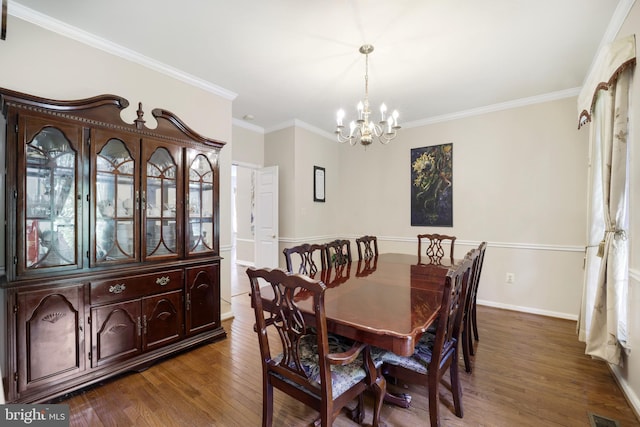 dining area with dark hardwood / wood-style flooring, crown molding, and a notable chandelier