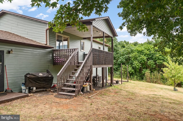 rear view of house featuring a deck and a lawn