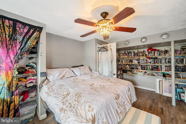 bedroom with ceiling fan, a textured ceiling, and dark hardwood / wood-style flooring