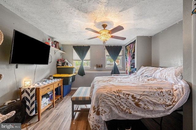 bedroom featuring ceiling fan, a textured ceiling, and hardwood / wood-style flooring