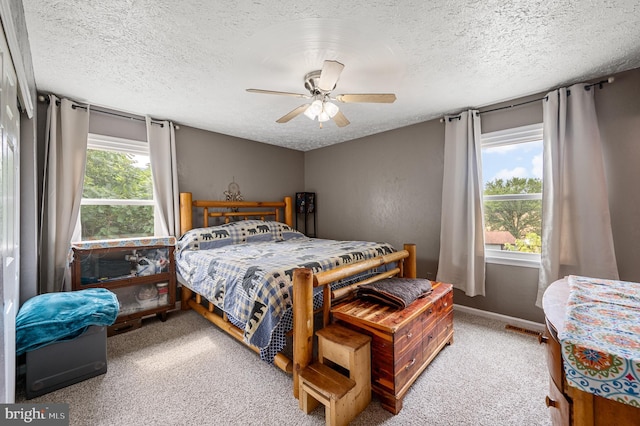 bedroom featuring ceiling fan, multiple windows, and carpet flooring