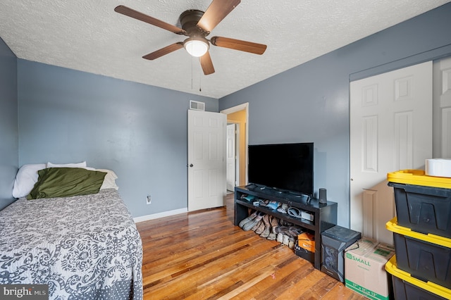 bedroom featuring a textured ceiling, ceiling fan, and hardwood / wood-style flooring