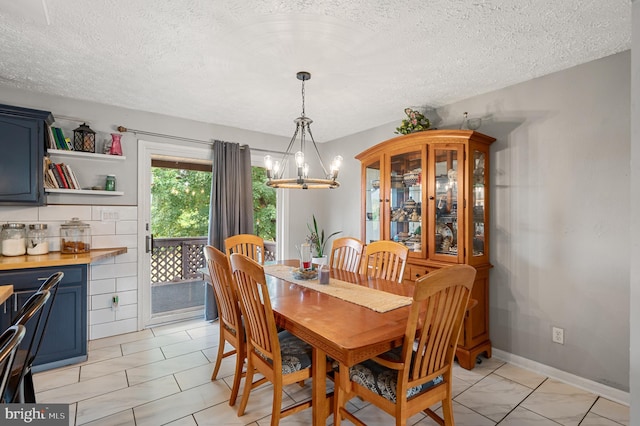 dining area with a textured ceiling, light tile patterned floors, and a chandelier