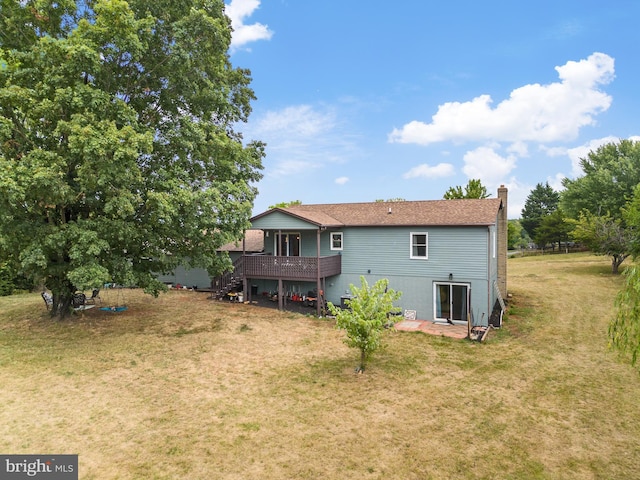 rear view of property featuring a deck and a yard