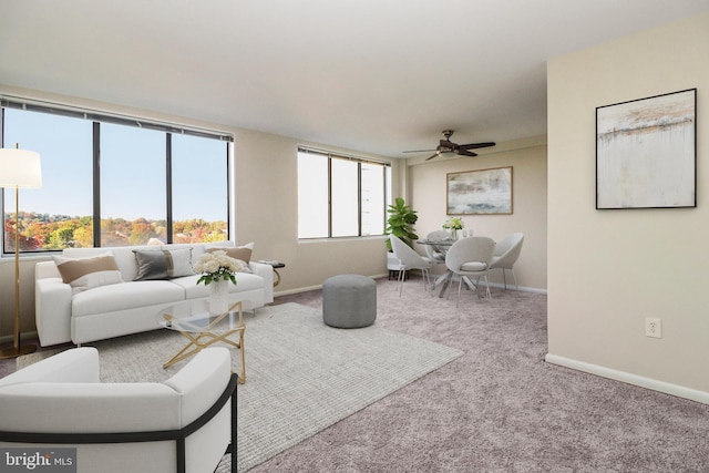 living room with ceiling fan, plenty of natural light, and carpet