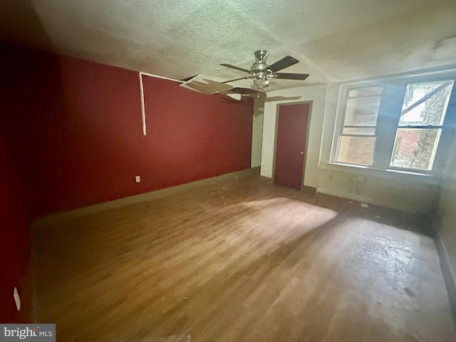 interior space featuring ceiling fan, wood-type flooring, and a textured ceiling