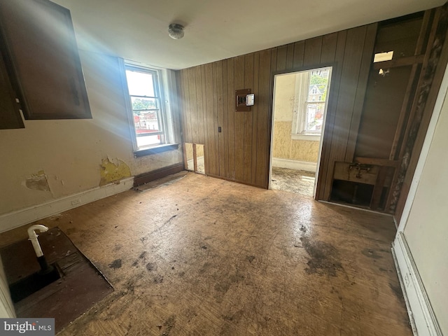 interior space with wooden walls and a baseboard heating unit