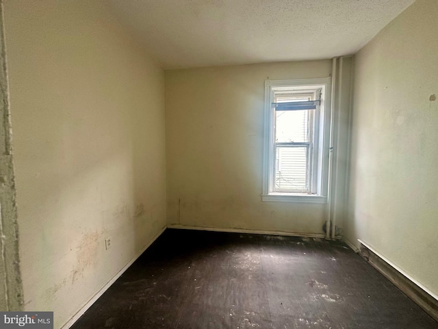 unfurnished room featuring a textured ceiling