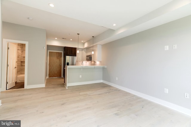 kitchen featuring dark brown cabinets, appliances with stainless steel finishes, kitchen peninsula, and light wood-type flooring