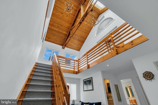 stairs featuring beamed ceiling, high vaulted ceiling, wooden ceiling, and a notable chandelier