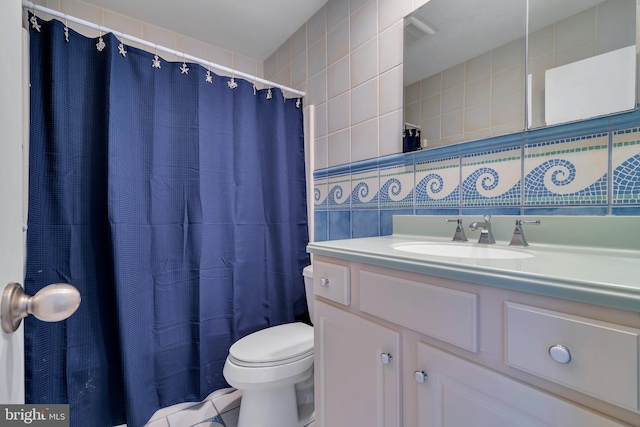 bathroom featuring vanity, toilet, tile walls, and tasteful backsplash