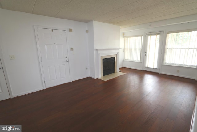 unfurnished living room with dark wood-type flooring and a fireplace