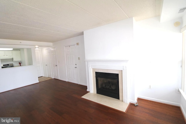 unfurnished living room with a high end fireplace and dark hardwood / wood-style flooring