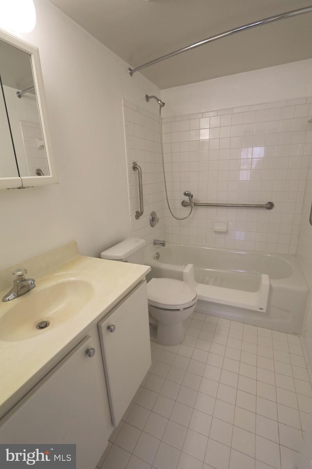 full bathroom featuring tiled shower / bath, vanity, toilet, and tile patterned floors