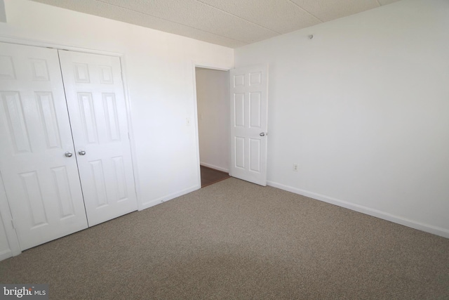 unfurnished bedroom with a closet and carpet flooring