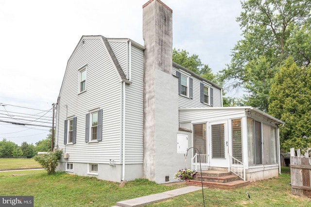 view of property exterior with a sunroom and a yard