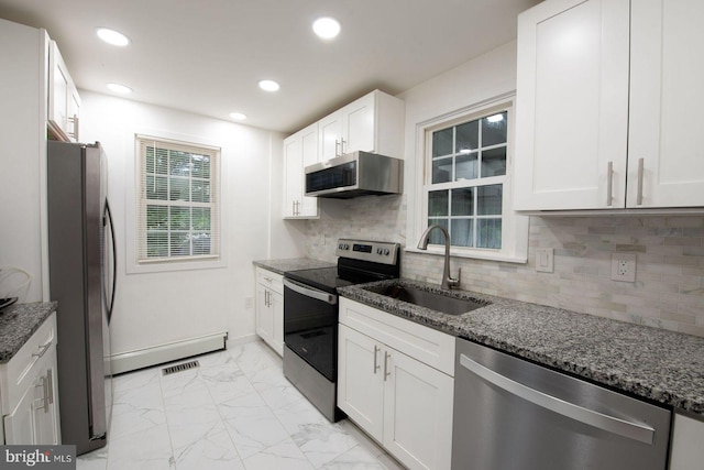 kitchen with sink, white cabinets, stainless steel appliances, and dark stone counters