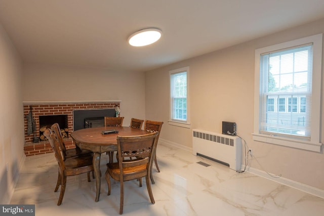 dining area featuring a fireplace and radiator heating unit