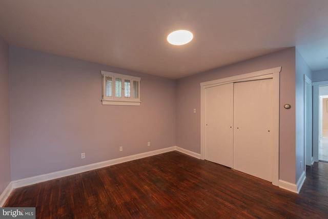 unfurnished bedroom featuring a closet and dark hardwood / wood-style flooring