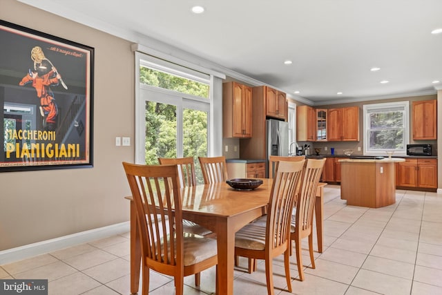 tiled dining area featuring crown molding