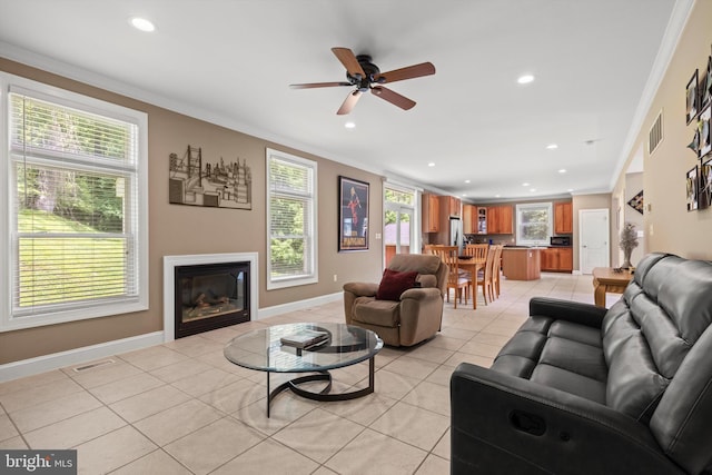 tiled living room featuring ceiling fan and crown molding