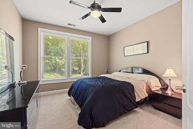 carpeted bedroom with multiple windows and ceiling fan