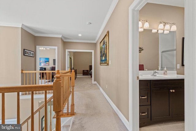 hallway featuring light colored carpet, ornamental molding, and sink