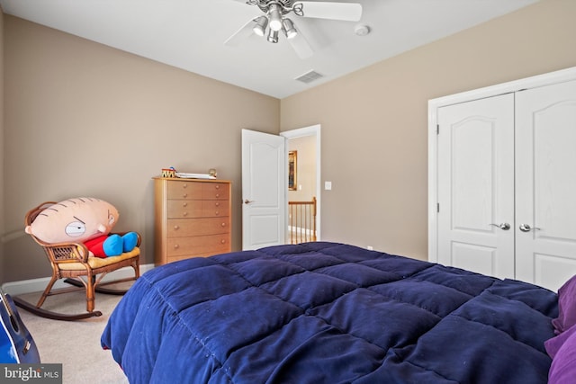 carpeted bedroom featuring ceiling fan and a closet