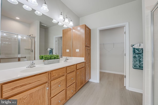 bathroom with vanity, wood-type flooring, and walk in shower