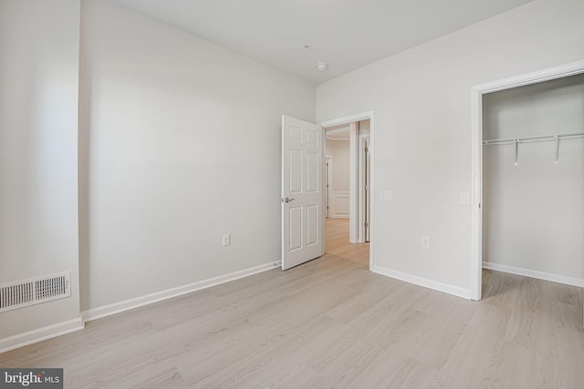 unfurnished bedroom featuring a closet and light hardwood / wood-style flooring