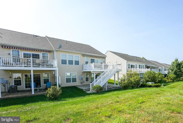 back of house with a patio, cooling unit, a wooden deck, and a lawn