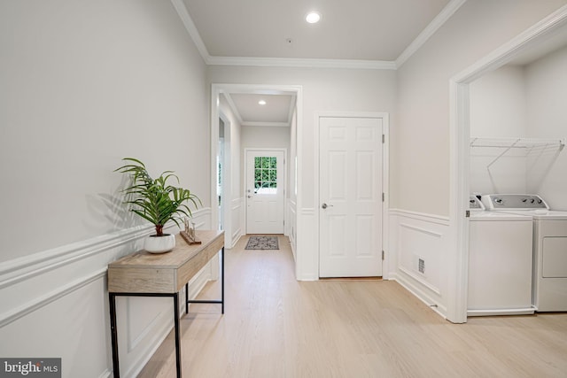 hallway with light hardwood / wood-style floors, washer and clothes dryer, and crown molding