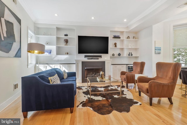 living room with wine cooler, crown molding, and light hardwood / wood-style floors