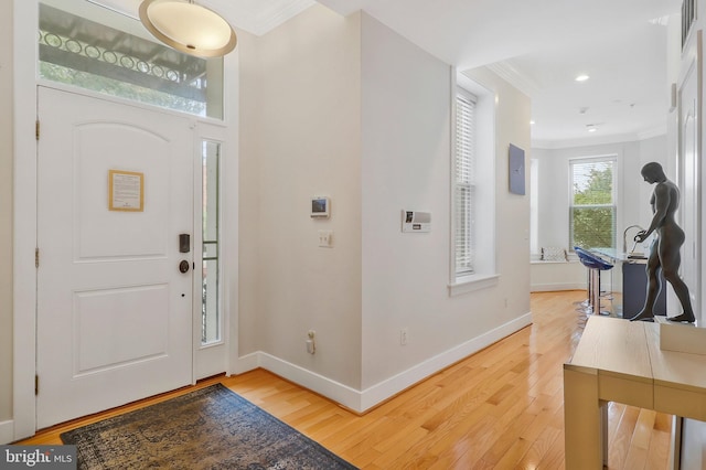 foyer featuring hardwood / wood-style flooring and crown molding