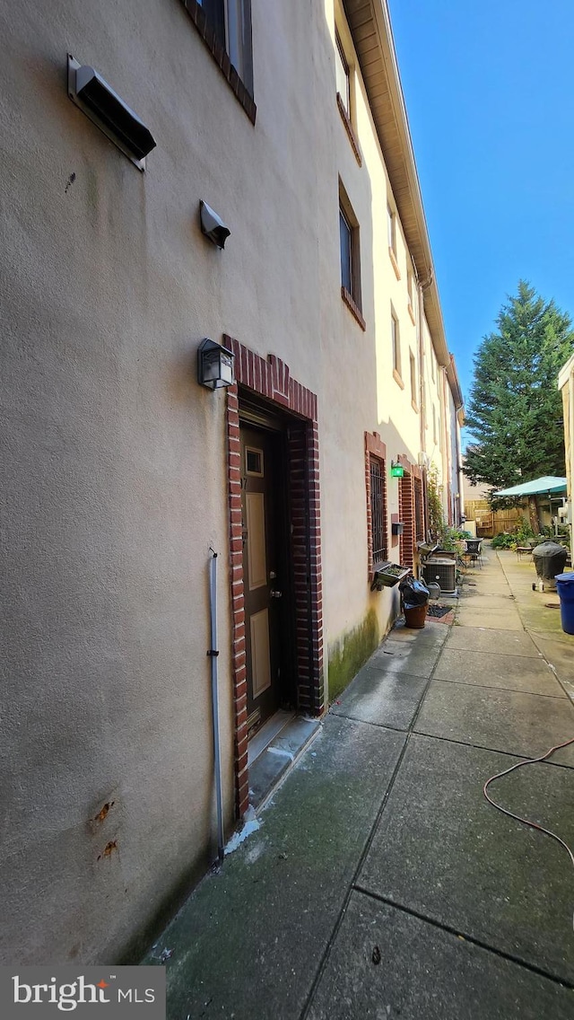 view of side of property with central AC unit and a patio