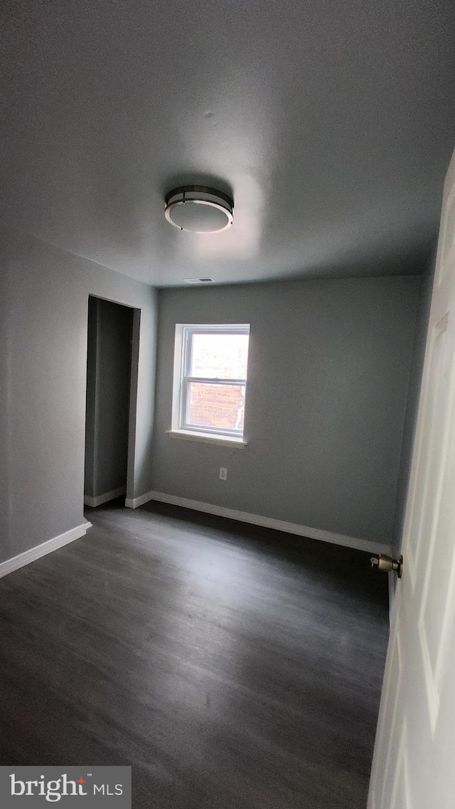 unfurnished bedroom with dark hardwood / wood-style floors