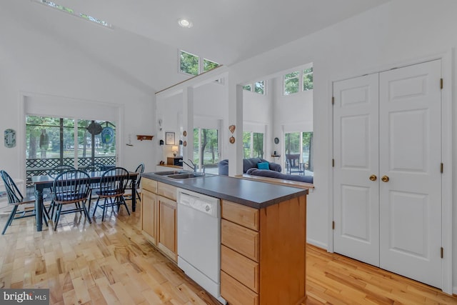 kitchen featuring light brown cabinets, sink, dishwasher, a kitchen island, and light hardwood / wood-style flooring