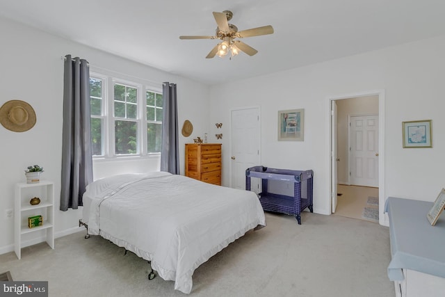 bedroom with ensuite bathroom, carpet floors, and ceiling fan