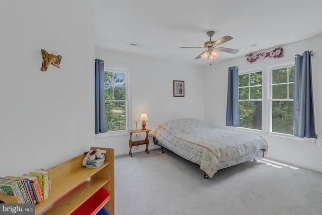 carpeted bedroom featuring multiple windows and ceiling fan