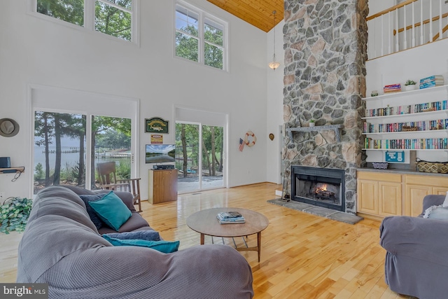 living room featuring a healthy amount of sunlight, light hardwood / wood-style flooring, and high vaulted ceiling