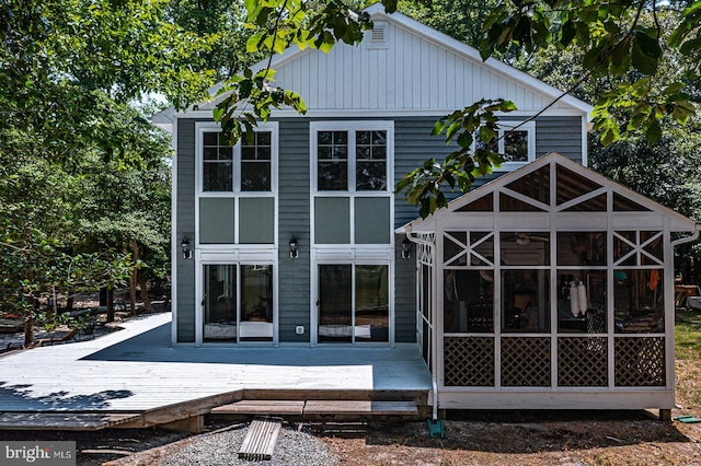 back of house with a sunroom and a deck