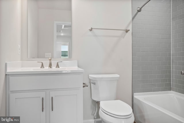 full bathroom featuring vanity, tiled shower / bath combo, and toilet