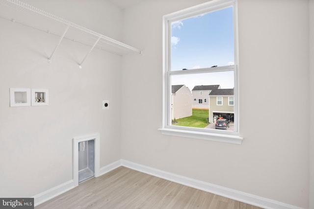 washroom with hookup for an electric dryer, washer hookup, and light hardwood / wood-style floors