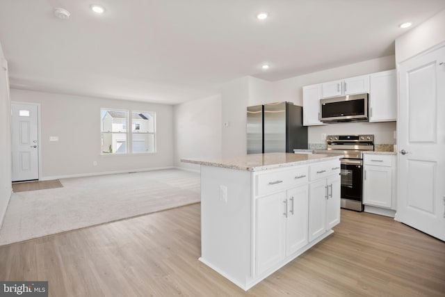 kitchen with white cabinetry, a kitchen island, light hardwood / wood-style floors, and appliances with stainless steel finishes