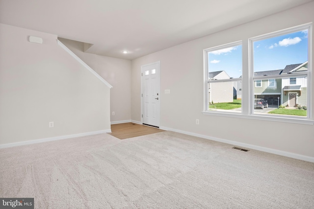 foyer entrance with light colored carpet